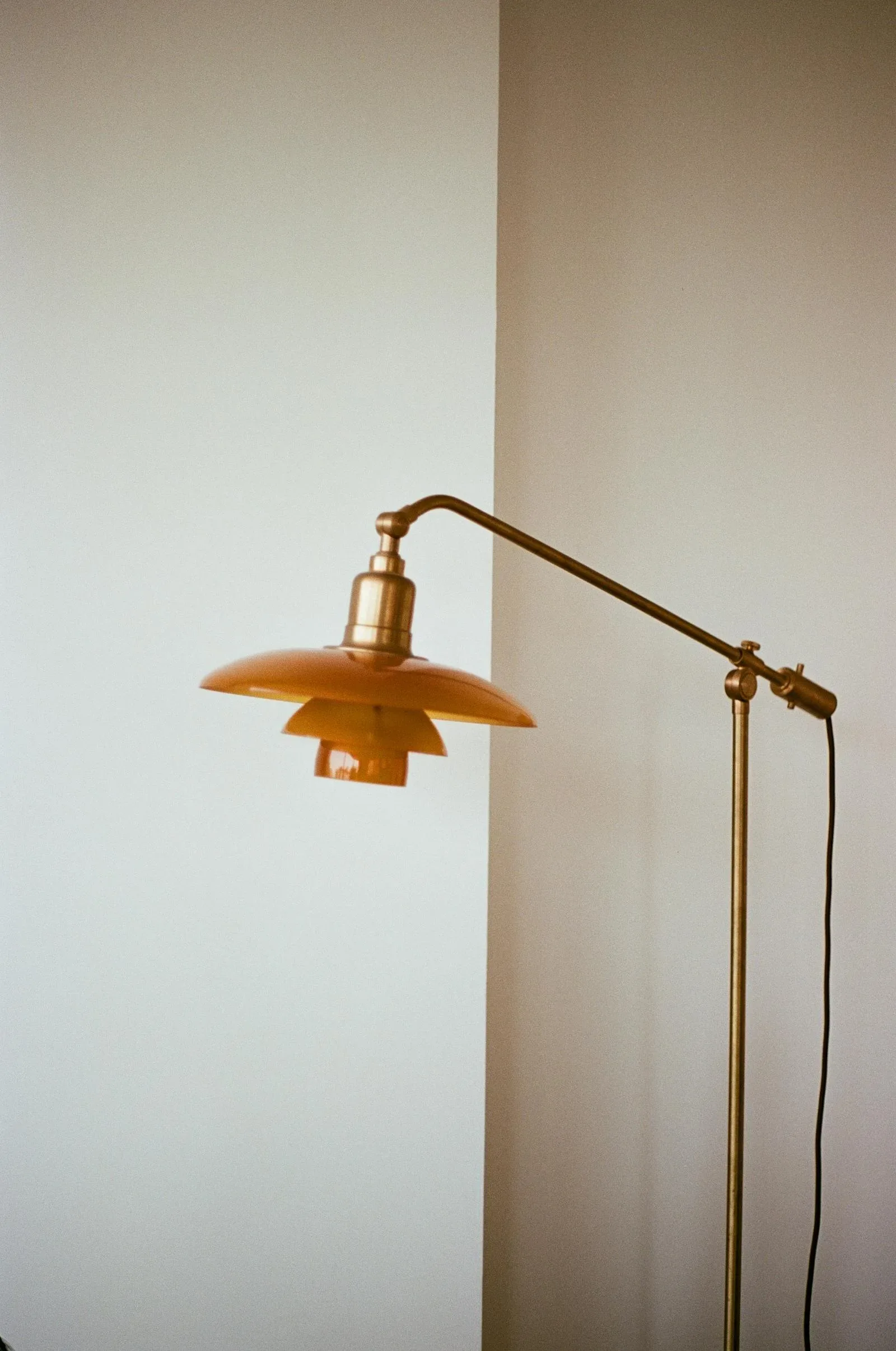 Warm brass lamp against a pale wall with soft directional light