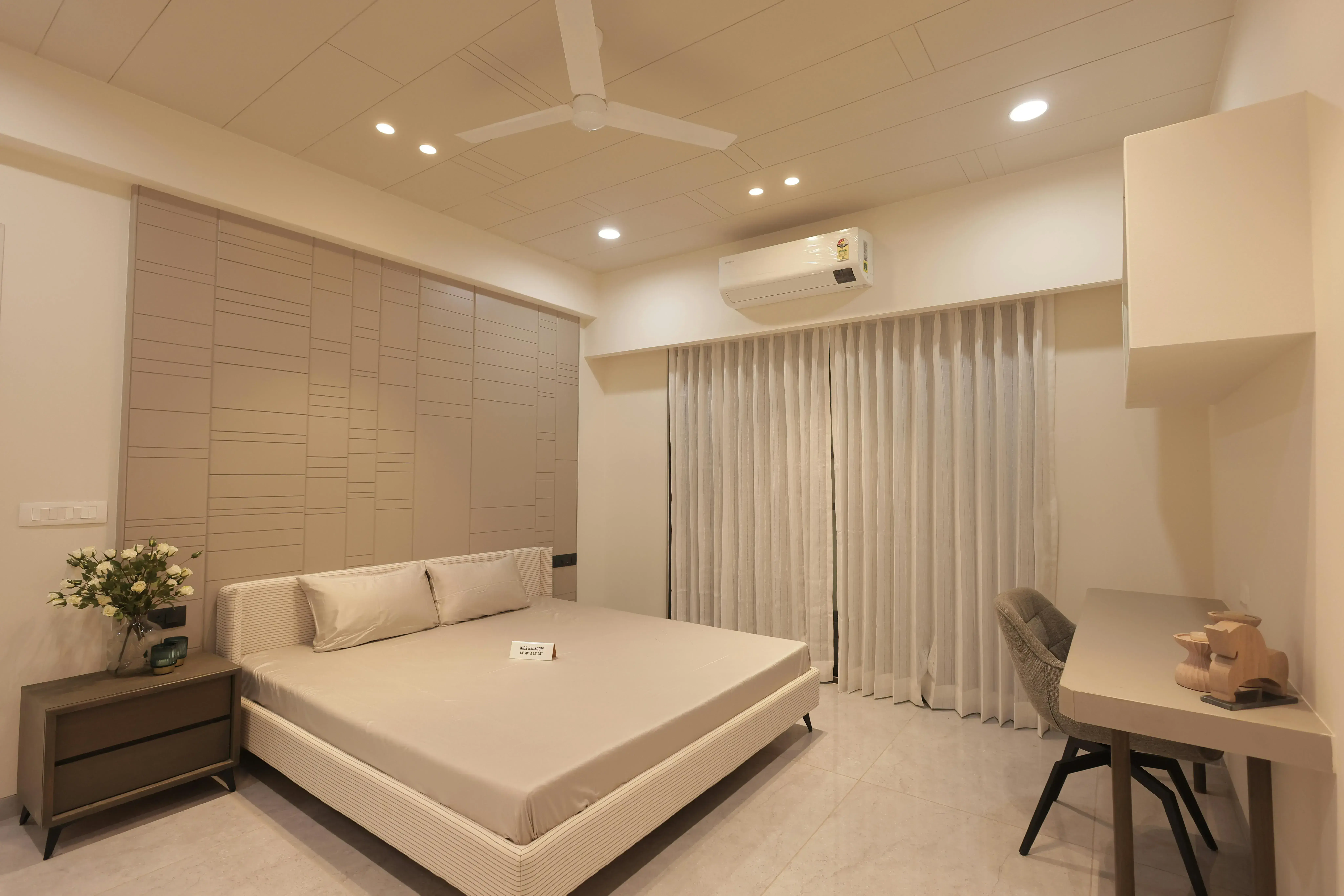 Bedroom with a bed, curtains, and a desk zone along the same wall showing a more mixed-use setup