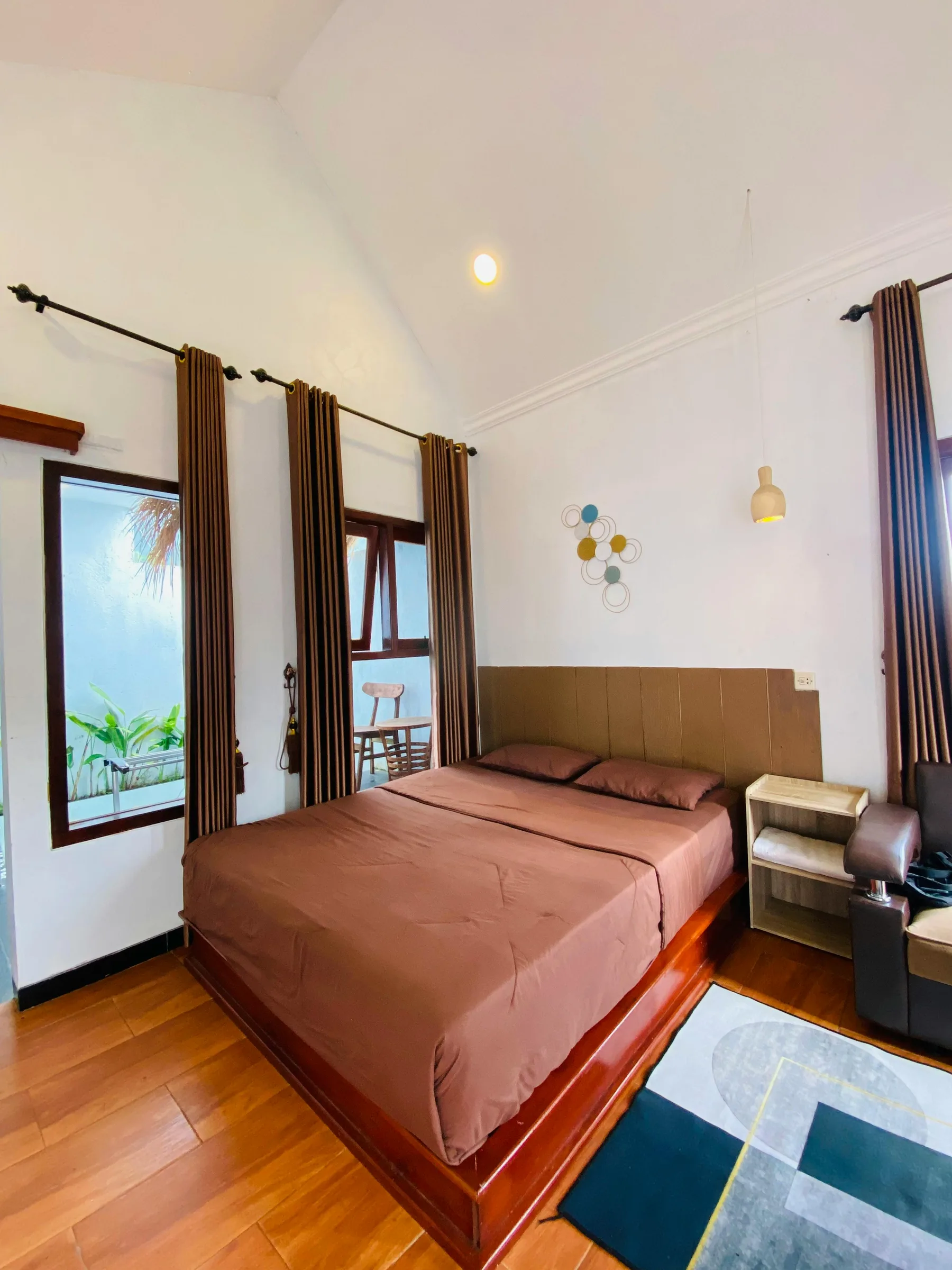 Bedroom with warm brown bed frame, layered bedding, and a steadier darker anchor in the room