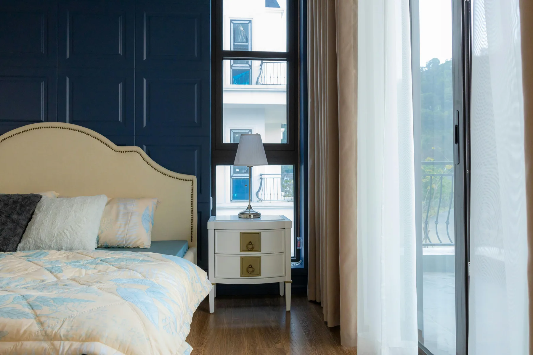 Elegant bedroom with natural light, a grounded bed wall, and calmer styling