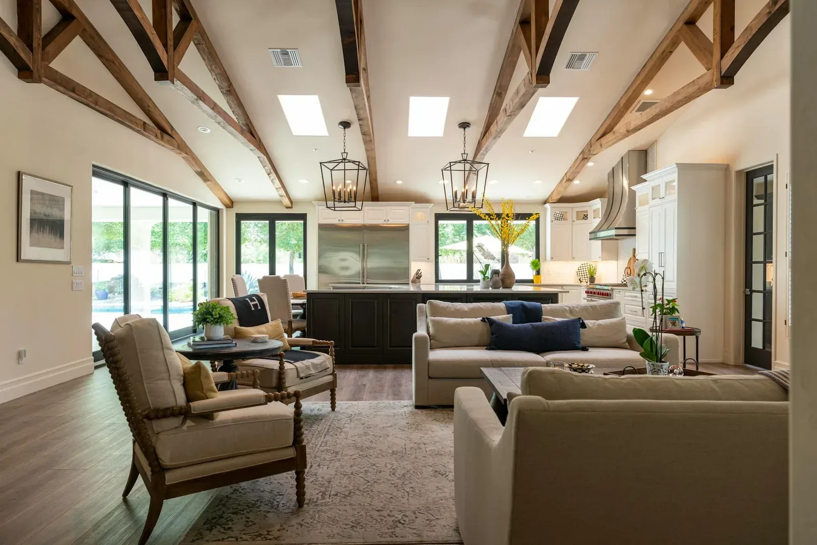 Open living room with beige seating, exposed beams, warm wood, and earth element neutral colors