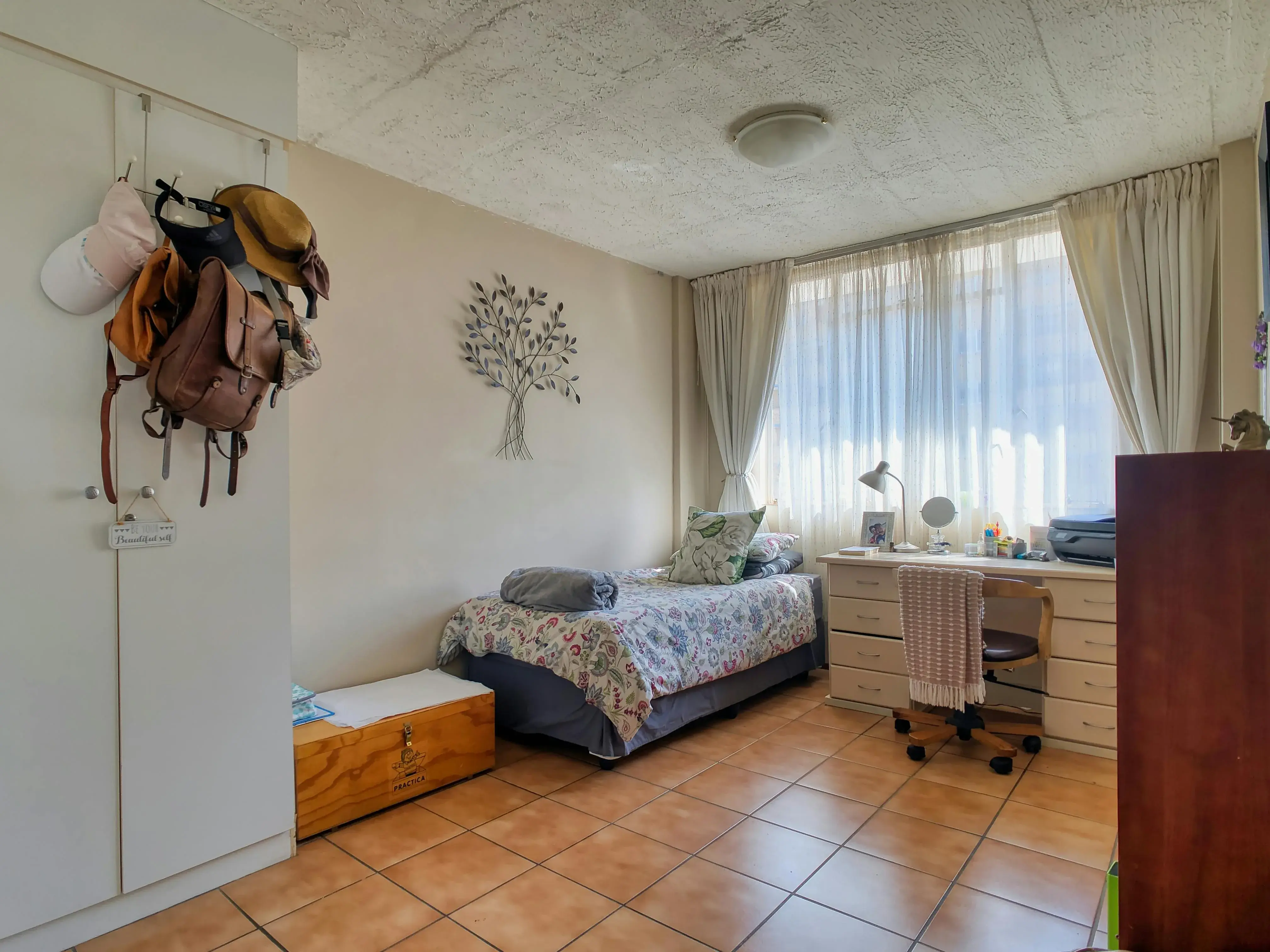 Bedroom with busy desk storage, visible work items, and a mixed-use feeling near the sleep space