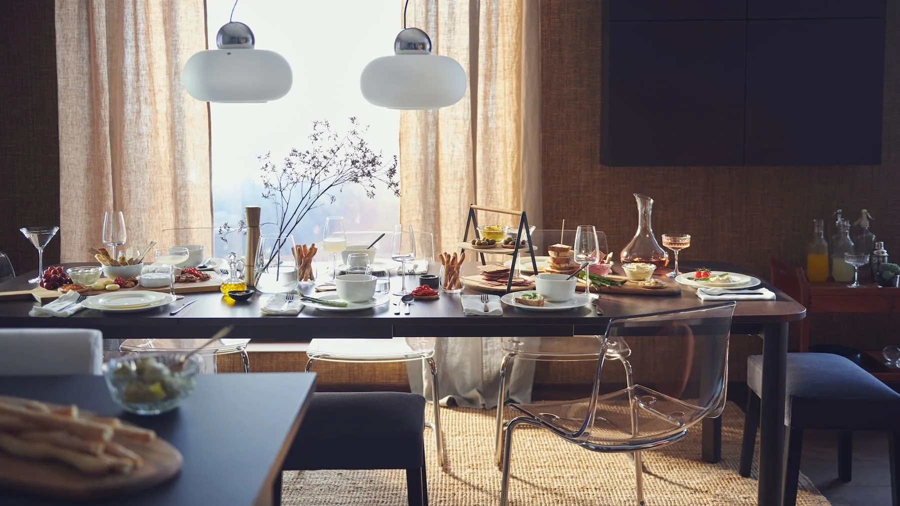 Dark dining table with soft pendant lights and warm curtains
