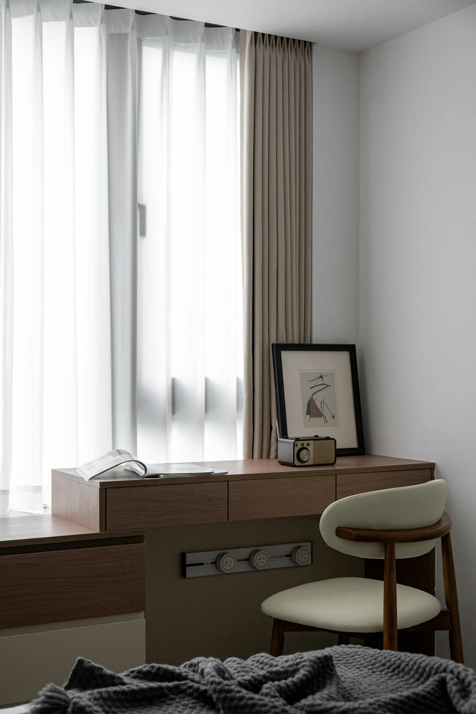 Minimal desk setup with soft curtains, clear surfaces, and a calm focused work area