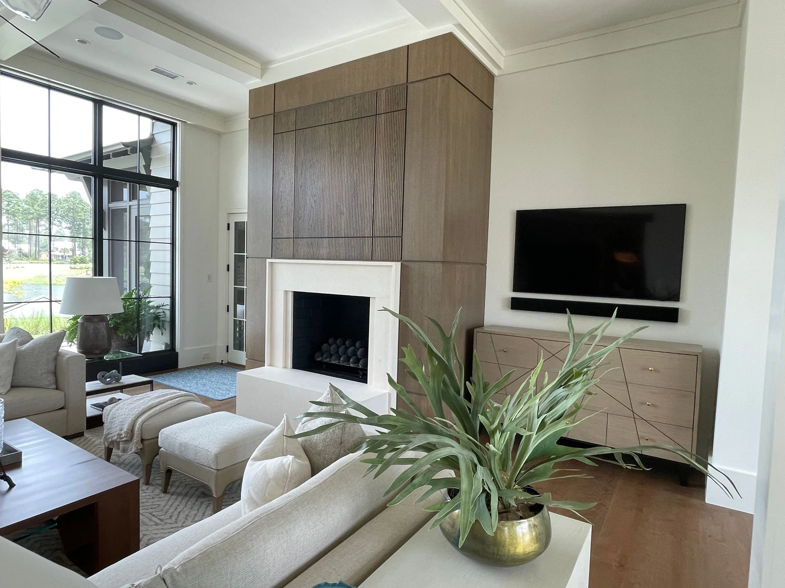 A bright living room with seating arranged around a fireplace and television