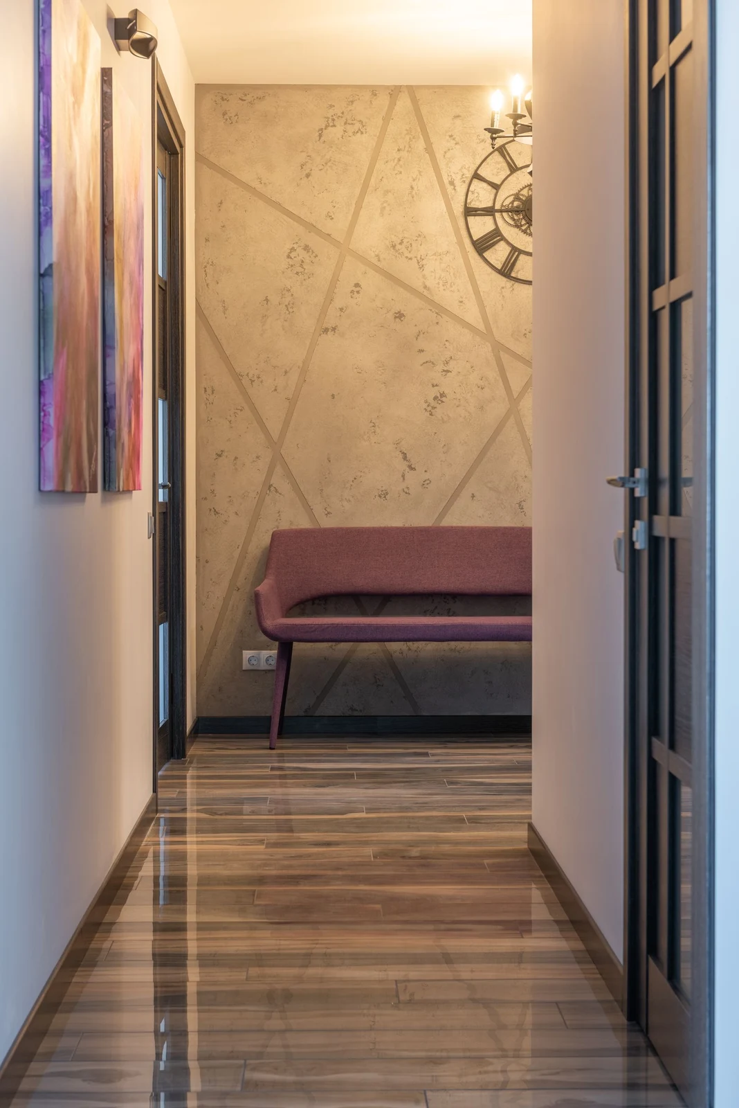 Clear passage opening toward a purple upholstered bench and a textured feature wall, with artwork along the side
