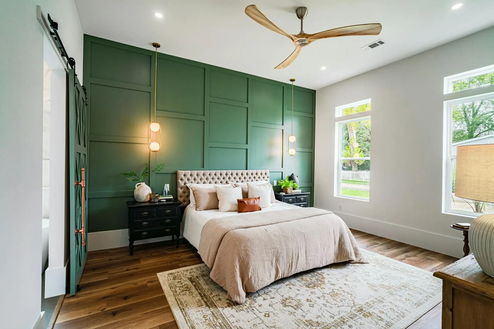 Bedroom with deep green paneled wall, warm bedding, and a calmer grounded palette