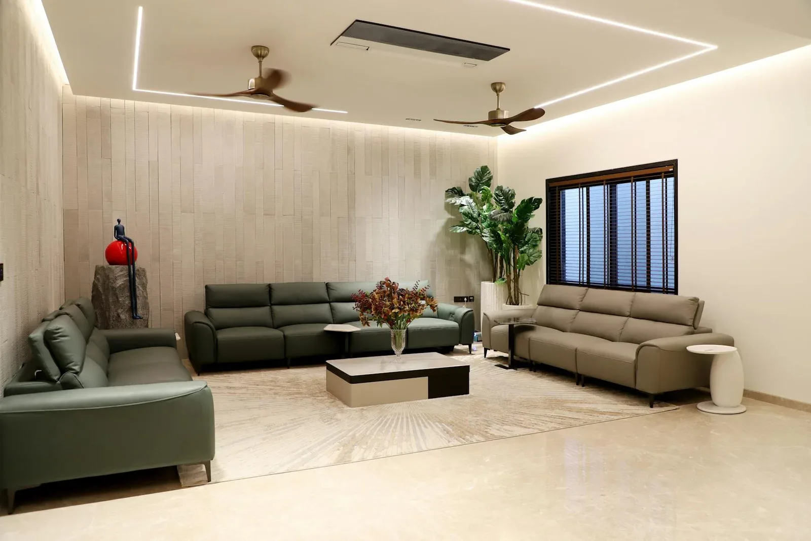 Living room with green sofas, plants, pale floor, and a calmer wood element palette