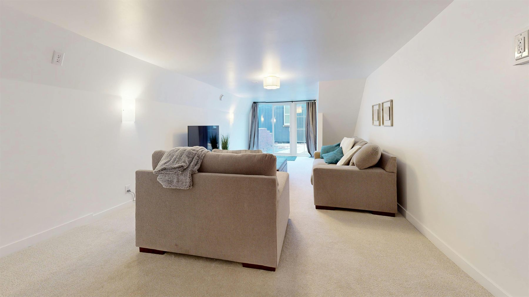 Long neutral interior with beige seating, soft walls, and a connected warm palette