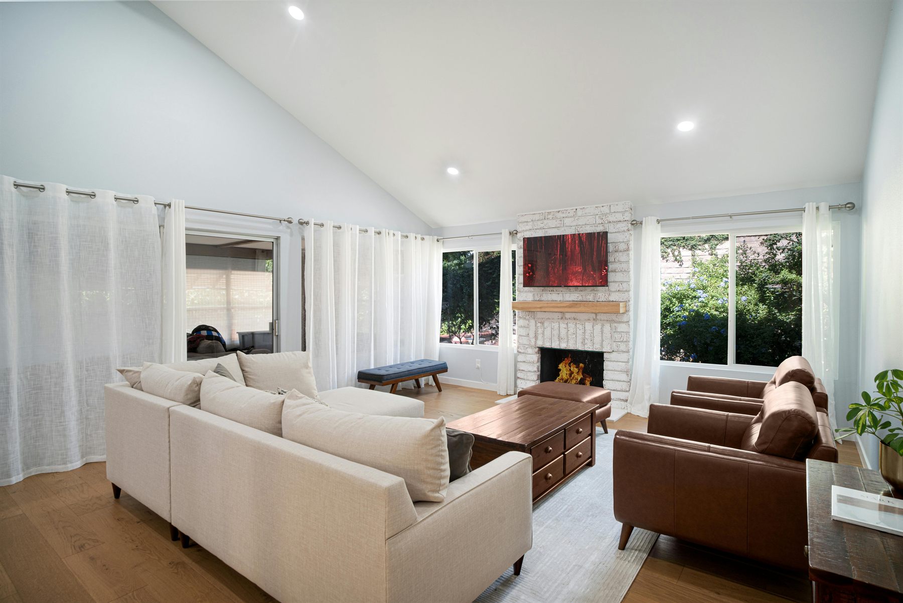 Bright connected living space with cream seating, warm wood, and a calm layered palette