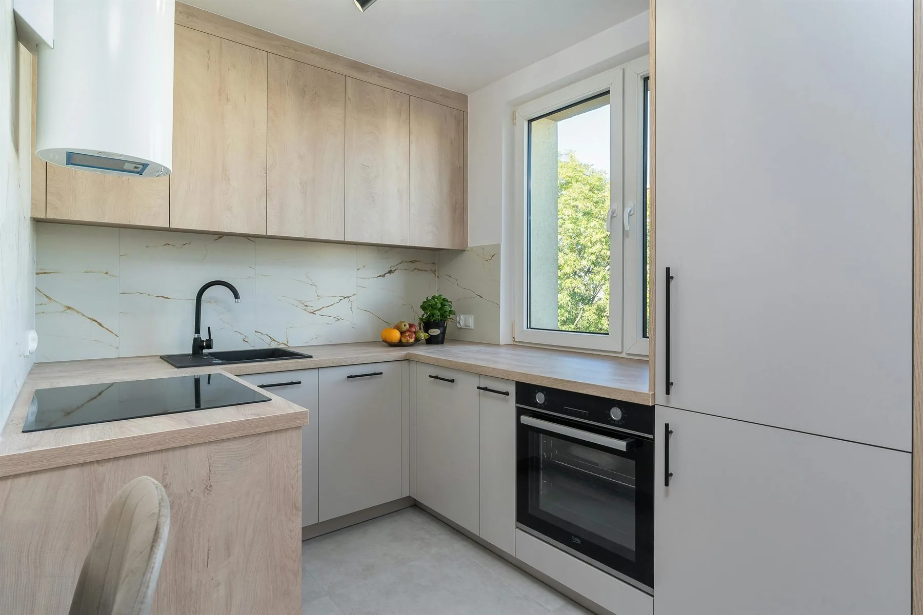 Kitchen with wood cabinetry, pale counters, and a calmer material mix