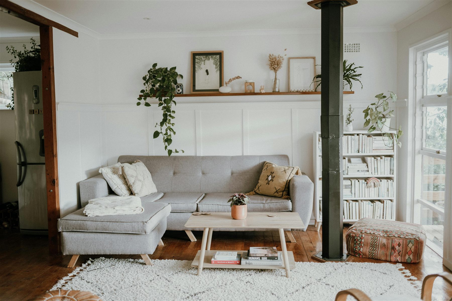 Airy living room with pale upholstery, wood coffee table, and a few plants
