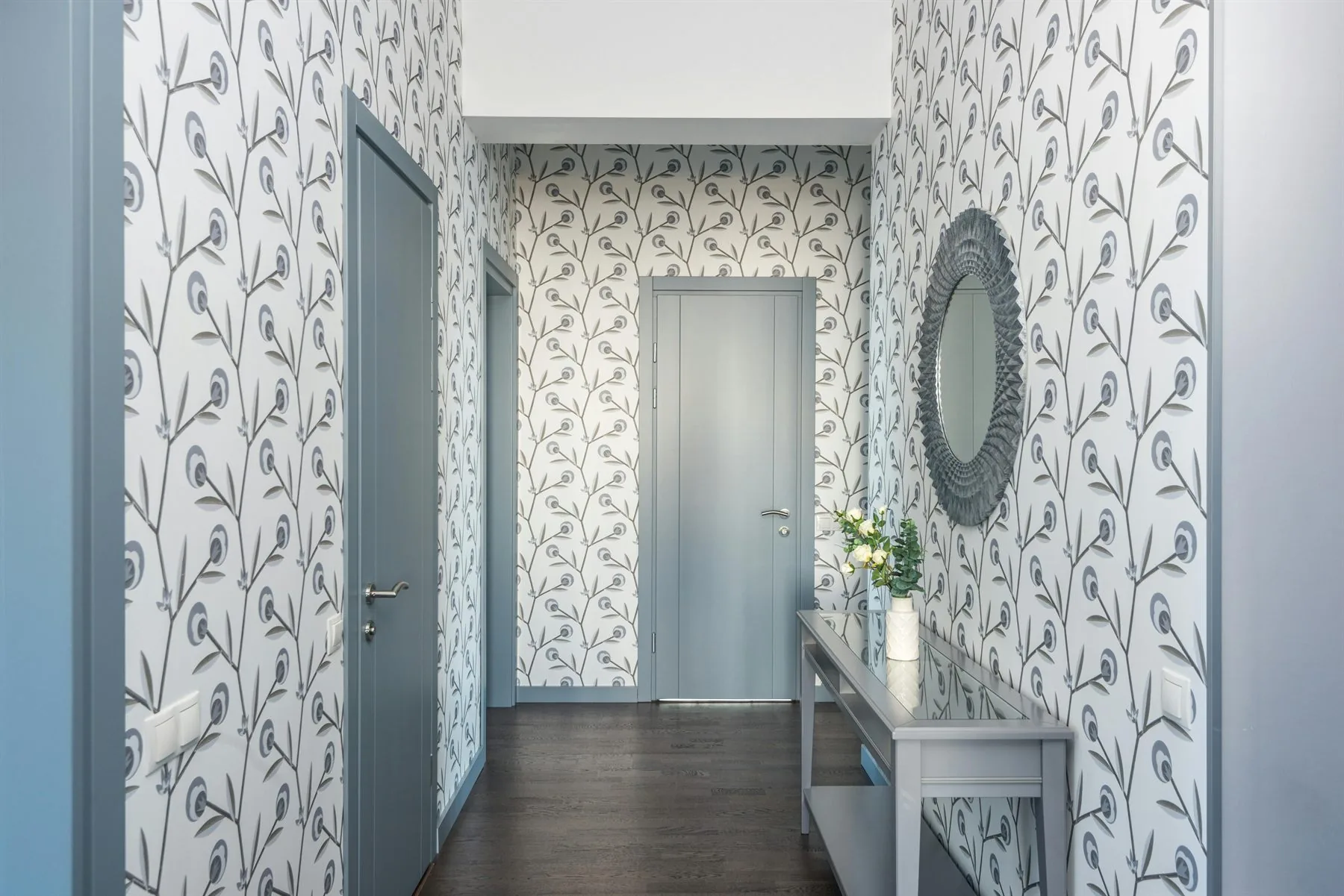 Hallway console with a mirror reflecting a calmer entry and soft light