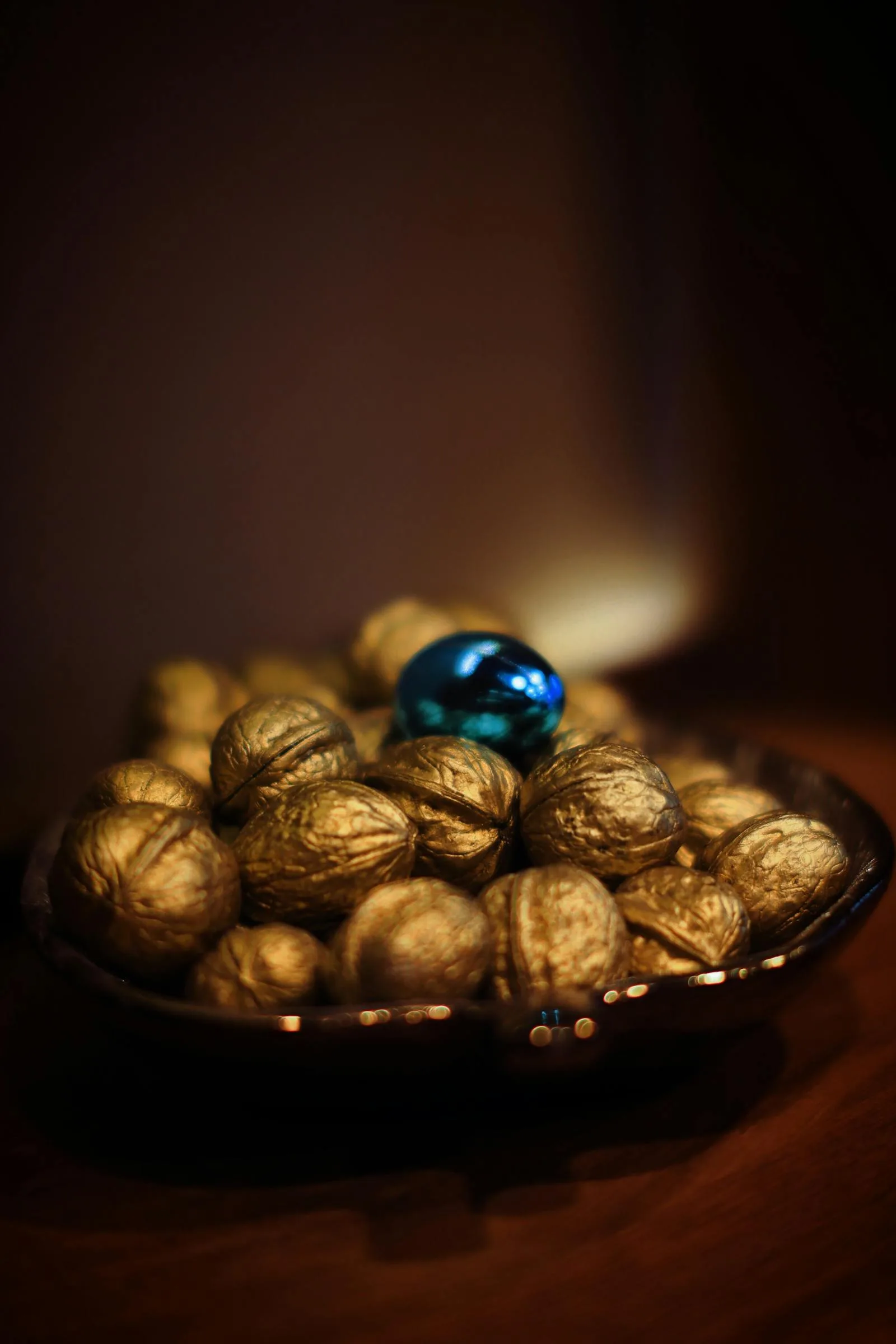 Gold-toned decorative bowl with warm light and a small blue ornament