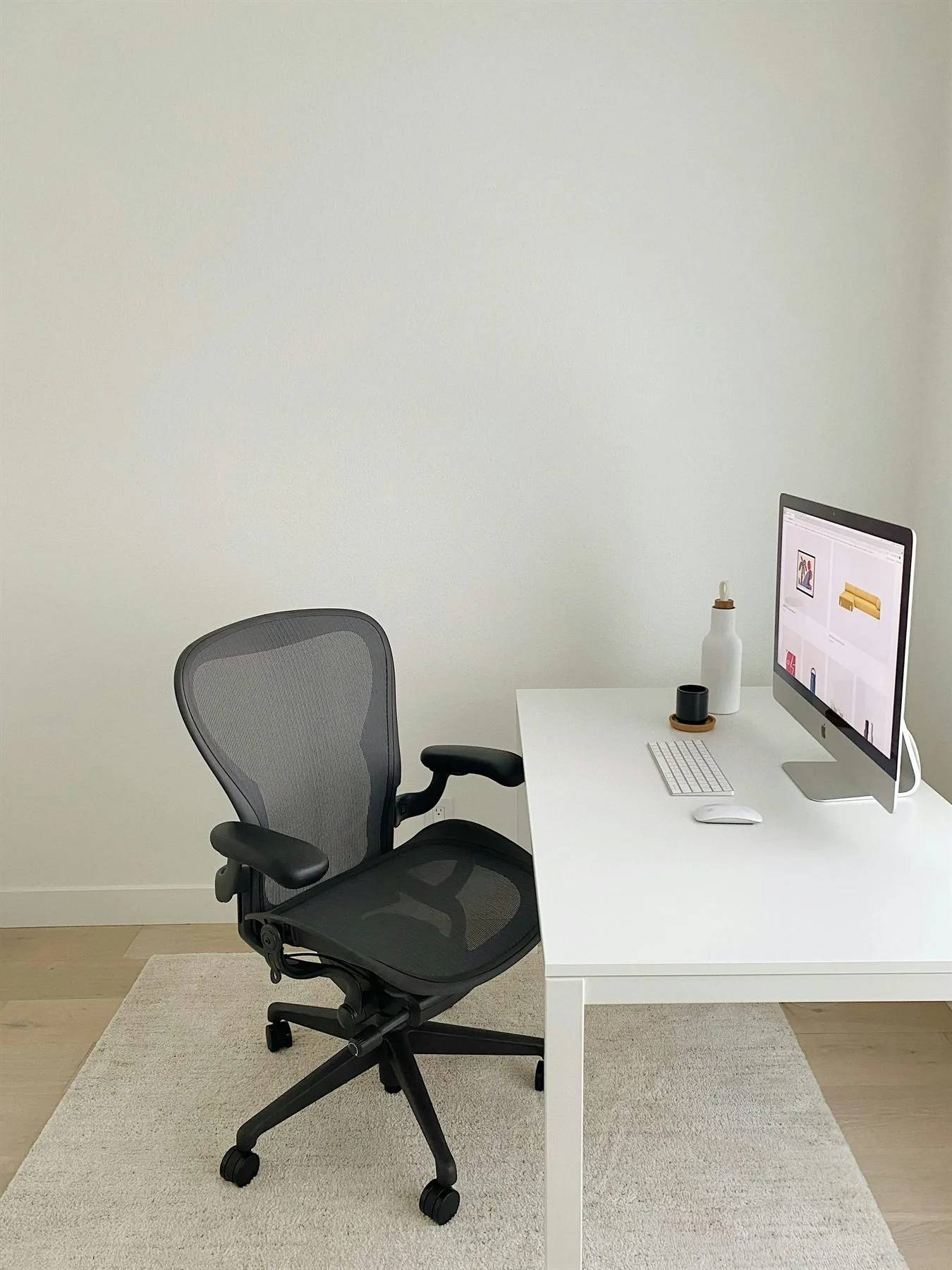 Minimal office with pale green-gray walls, white desk, and a calm focused layout