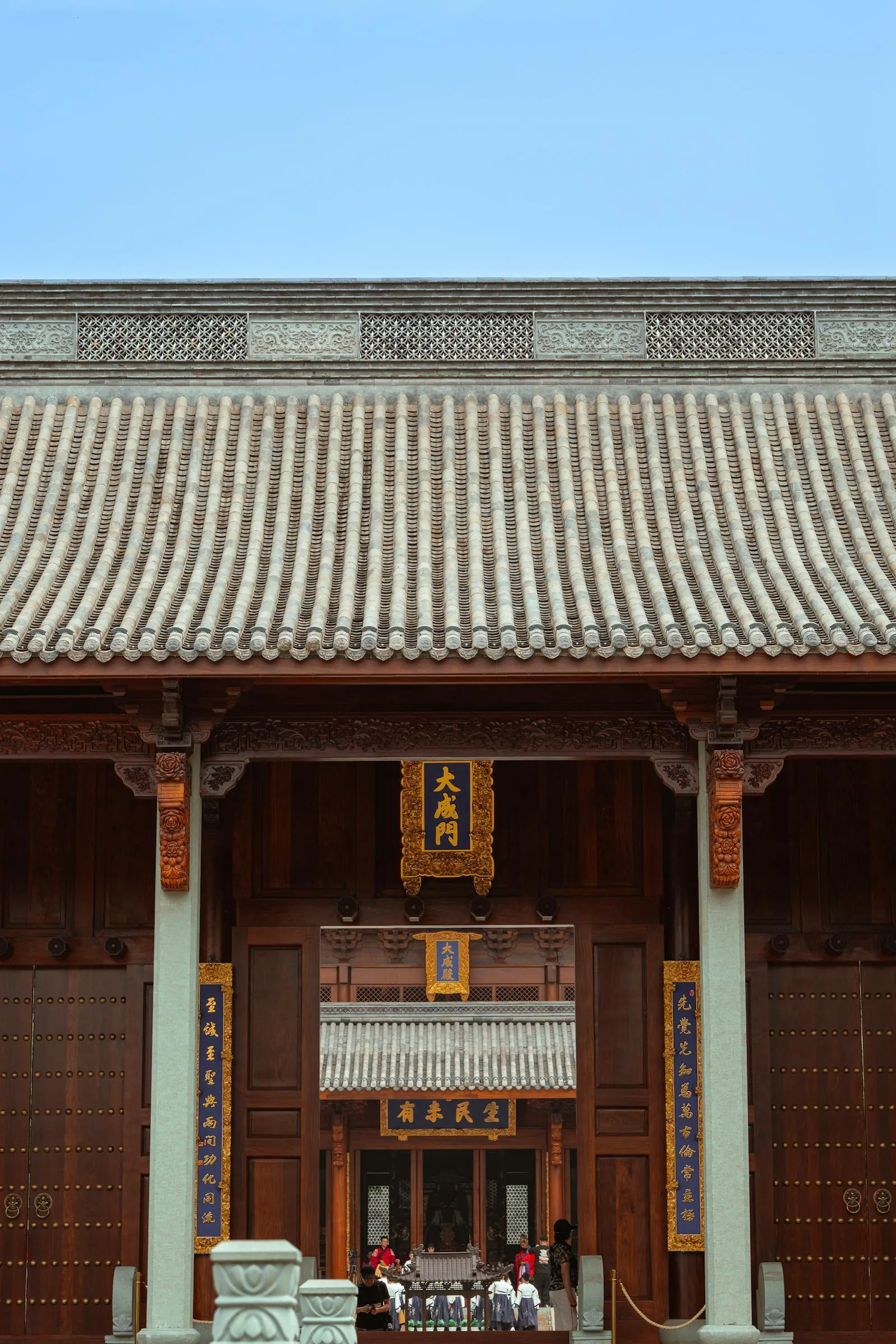 Traditional Chinese hall with tiled roof, carved columns, and a central doorway
