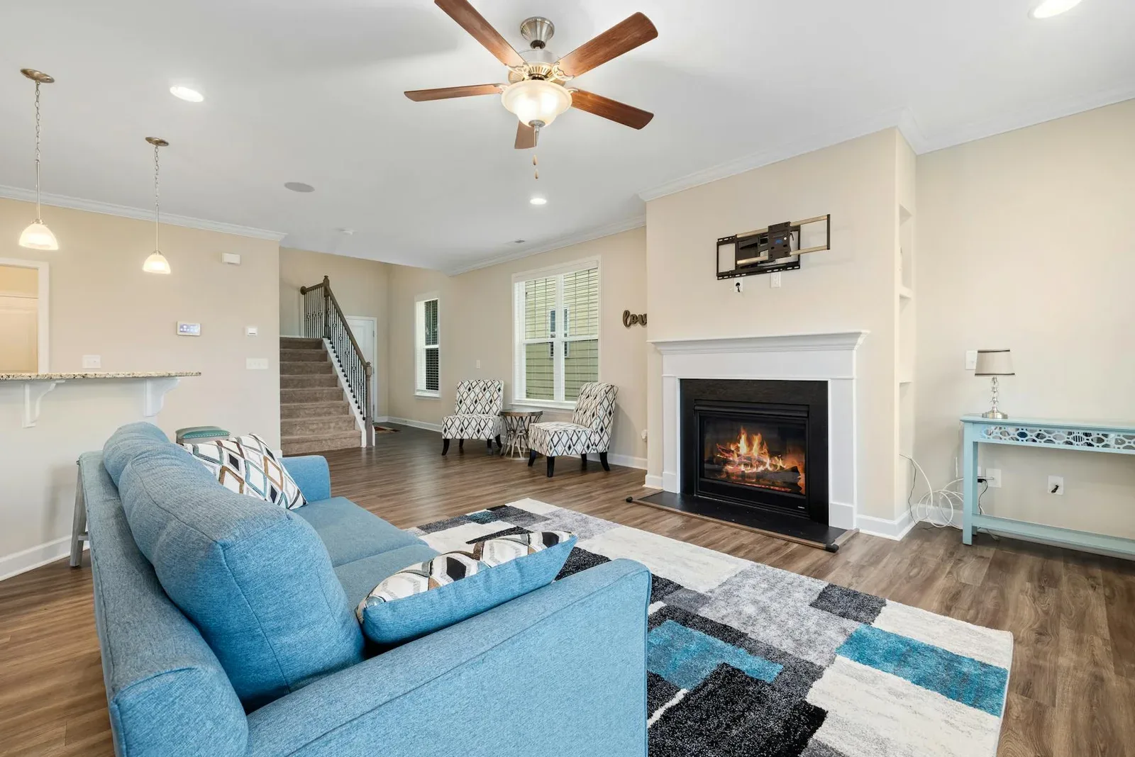 Living room with blue sofa, warm fireplace, cream walls, and a balanced cool color palette