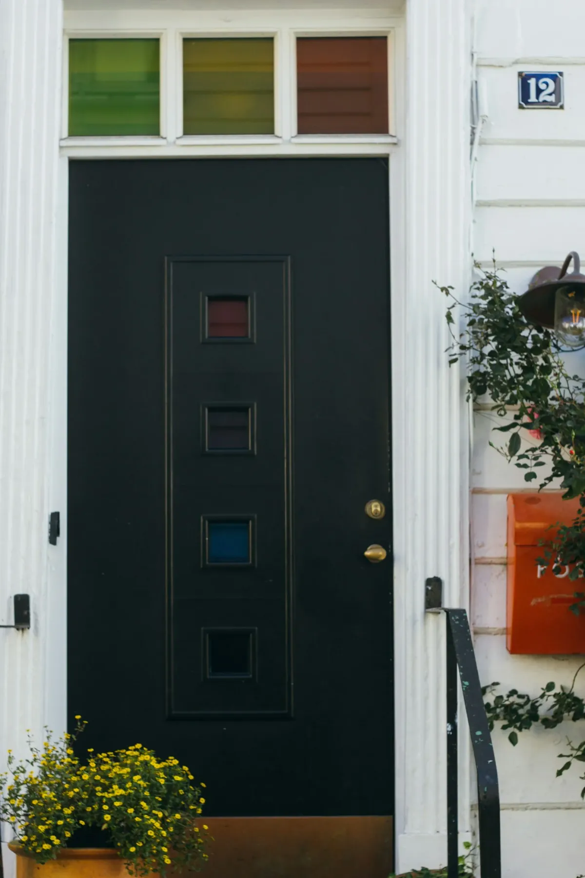 Black front door with a potted plant beside it