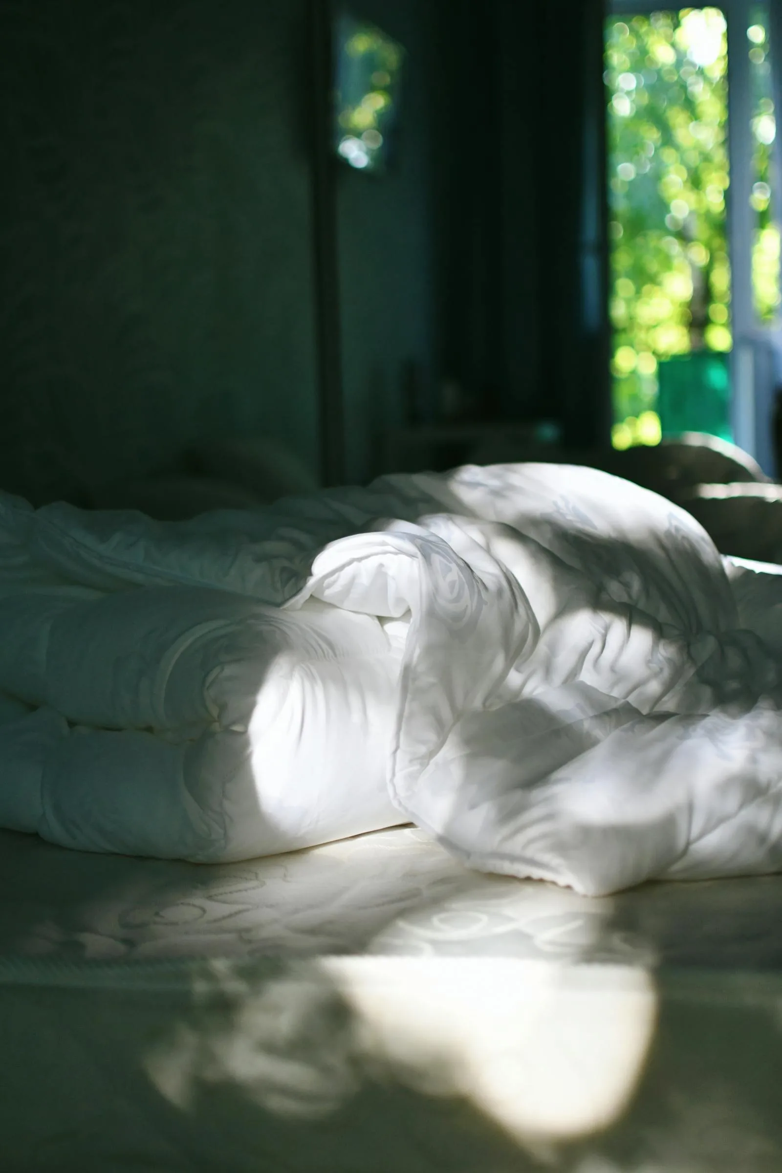 Soft rumpled bed in calm morning light with a quiet restful mood