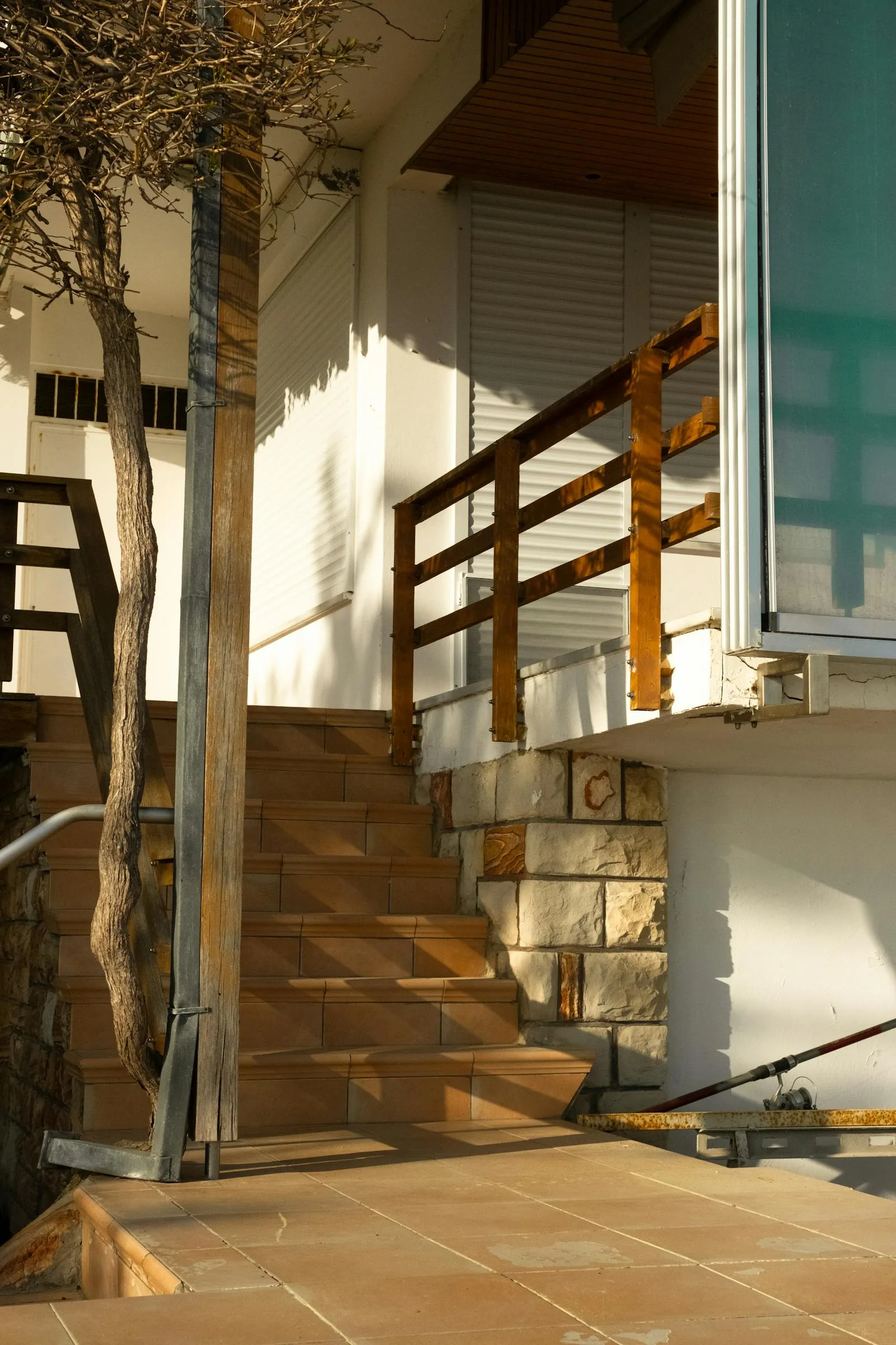 Sunlit exterior steps and entry of a south facing house with strong afternoon light