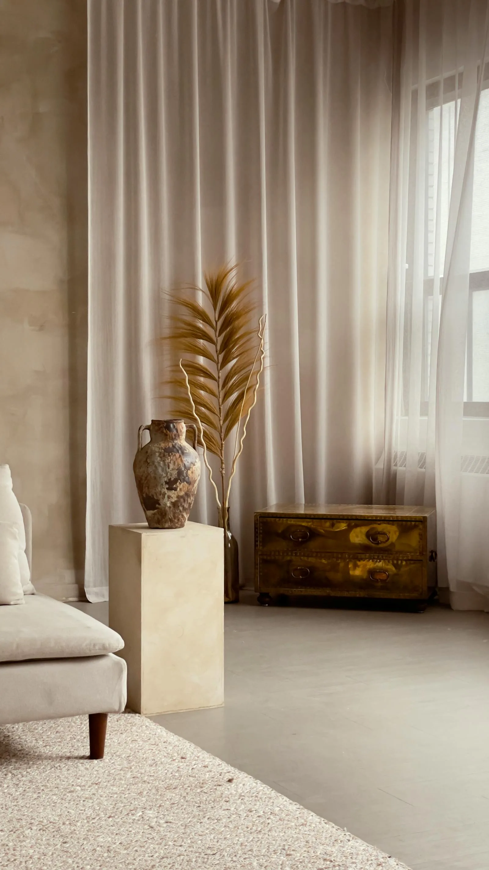 Soft neutral room with tall curtains, aged vase, and a calm minimal wabi sabi mood