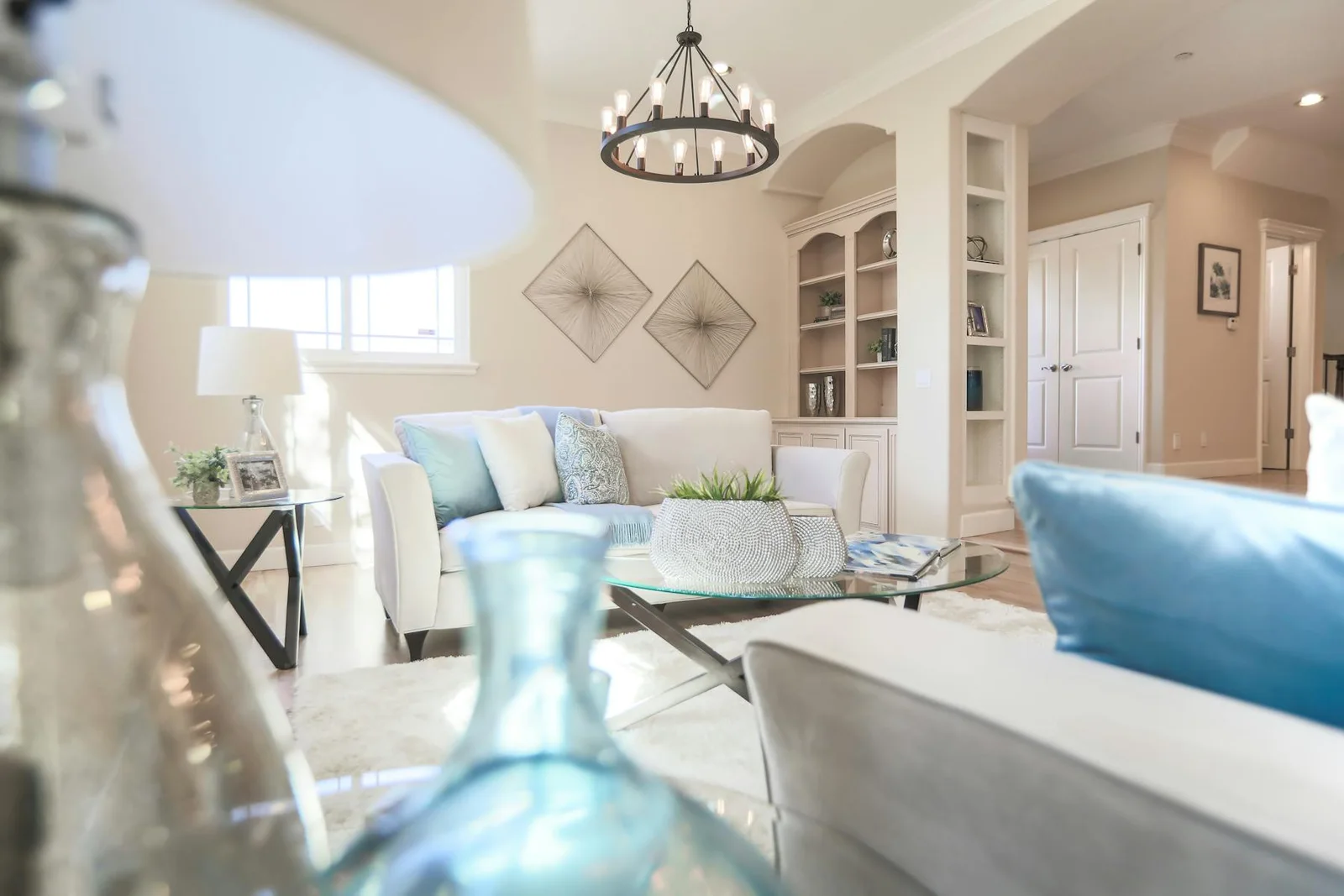Bright living room with pale blue accents, warm light, and soft neutral seating