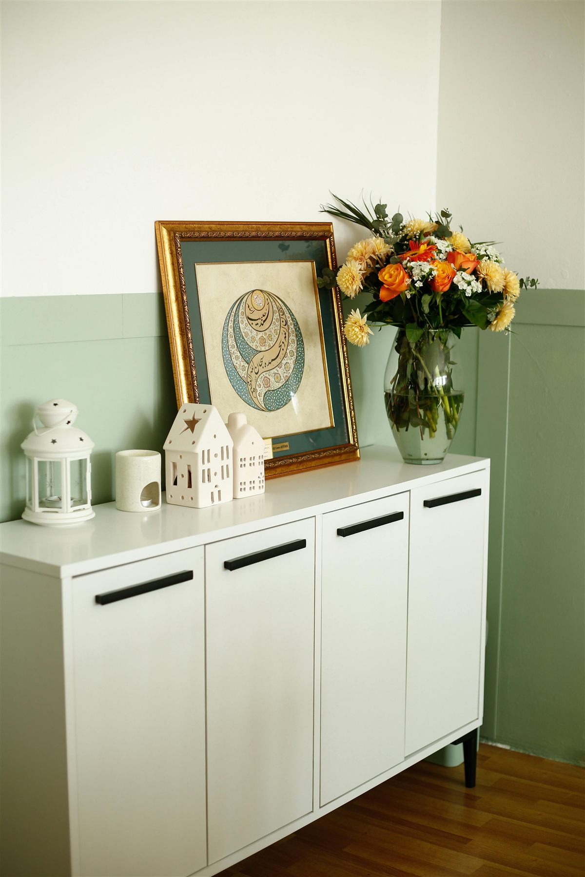Styled console with framed art, flowers, and a calm abundance-focused arrangement