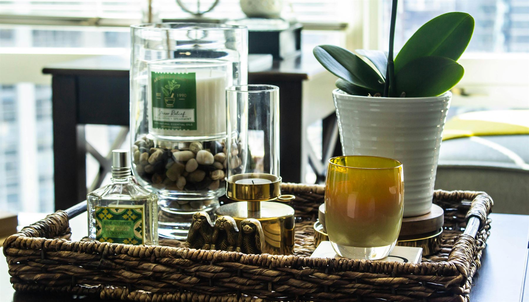 Tray with a candle, plant, and a few calm decor objects beside a bright window