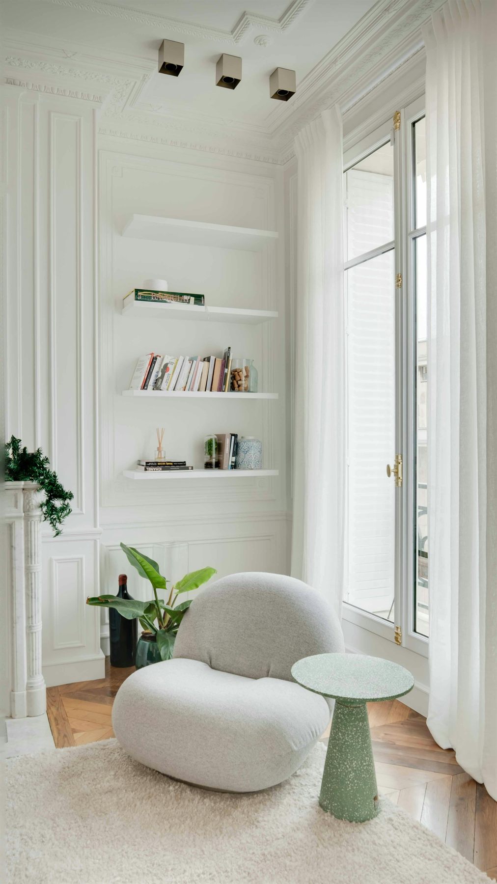 Room with white walls, green accents, and natural wood details showing a softer wood element direction